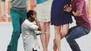 Pramusaji membawa pesanan melewati sebuah iklan di Mumbai pada 13 Januari 2014. Sebuah penelitian baru dari PBB memprediksi bahwa India akan melampaui China sebagai negara dengan penduduk terbanyak pada tahun 2022. (AFP PHOTO/INDRANIL MUKHERJEE)