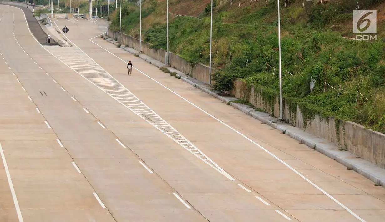 Warga berjalan di proyek Tol Cijago Seksi II di kawasan Depok, Jawa Barat, Kamis (6/9). Progres pembangunan proyek Tol Cijago Seksi II telah mencapai 90 persen. (Liputan6.com/Immanuel Antonius)