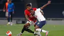 Striker Manchester United, Marcus Rashford berebut bola dengan pemain Tottenham Hotspur Serge Aurier dalam laga Liga Inggris di Stadion Tottenham, London, Jumat (19/6/2020). Manchester United berhasil mencuri poin di markas Hotspur dengan skor imbang 1-1.  (AP/ Matt Childs, Pool)