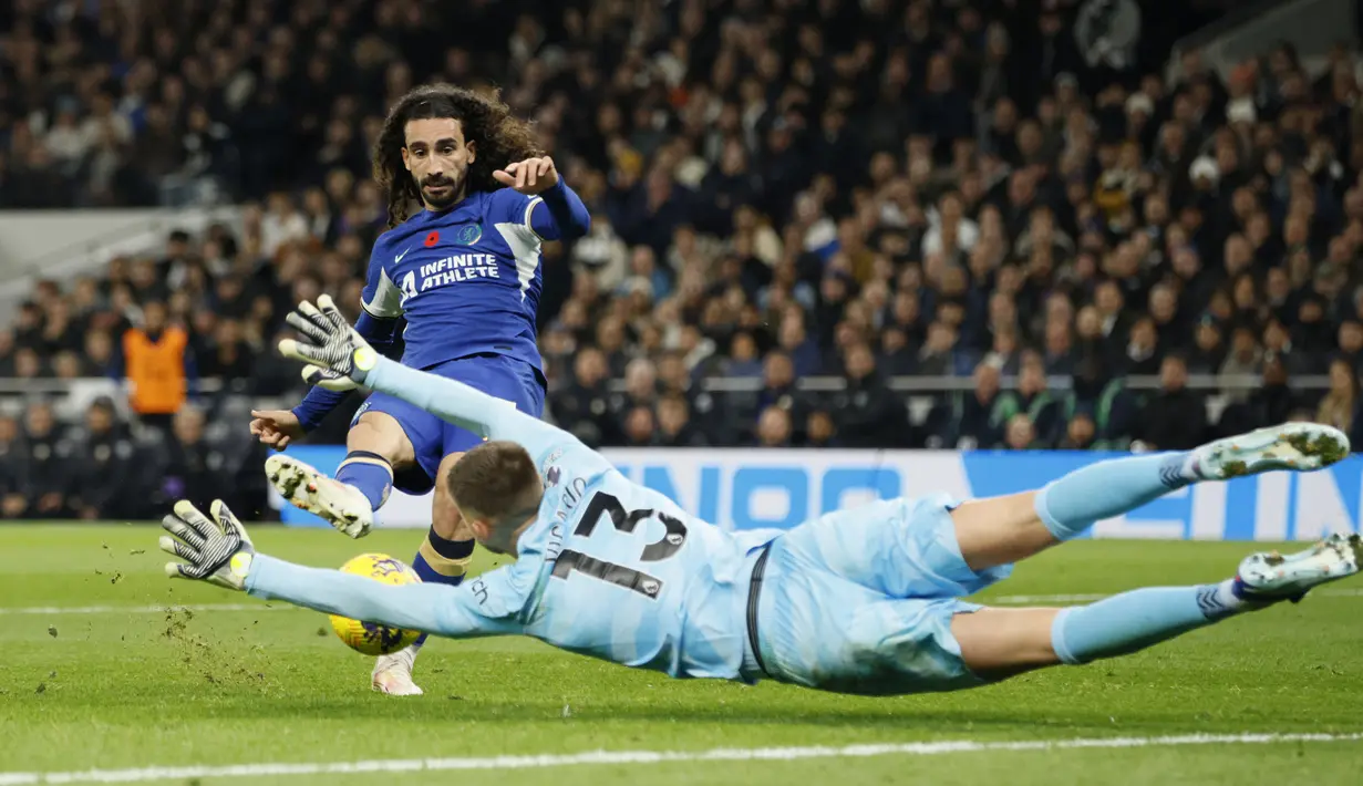 Kiper Tottenham Hotspur, Guglielmo Vicario melakukan penyelamatan dari tendangan bek Chelsea, Marc Cucurella pada laga lanjutan pekan ke-11 Liga Inggris 2023/2024 di Tottenham Hotspur Stadium, London, Selasa (7/11/2023) dini hari WIB. (AP Photo/David Cliff)
