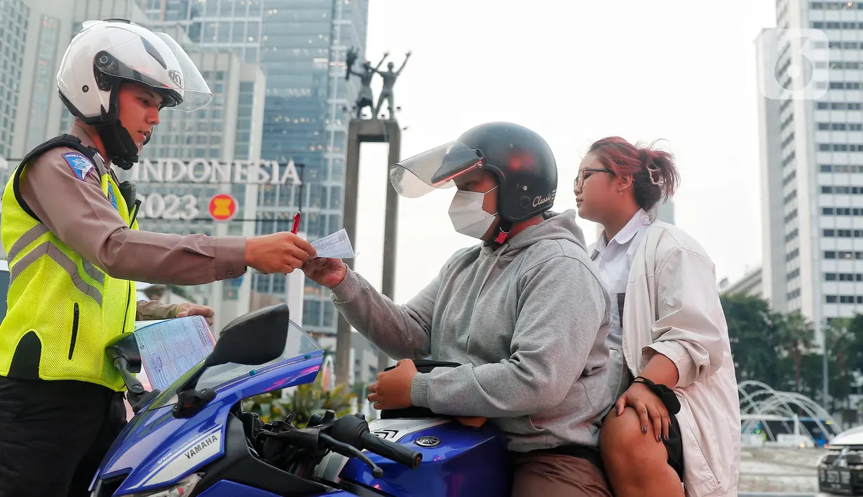 Polisi melakukan penindakan sanksi tilang kepada pengendara motor yang melakukan pelanggaran di Bundaran Hotel Indonesia (HI), Jakarta, Senin (15/5/2023). (Liputan6.com/Angga Yuniar)