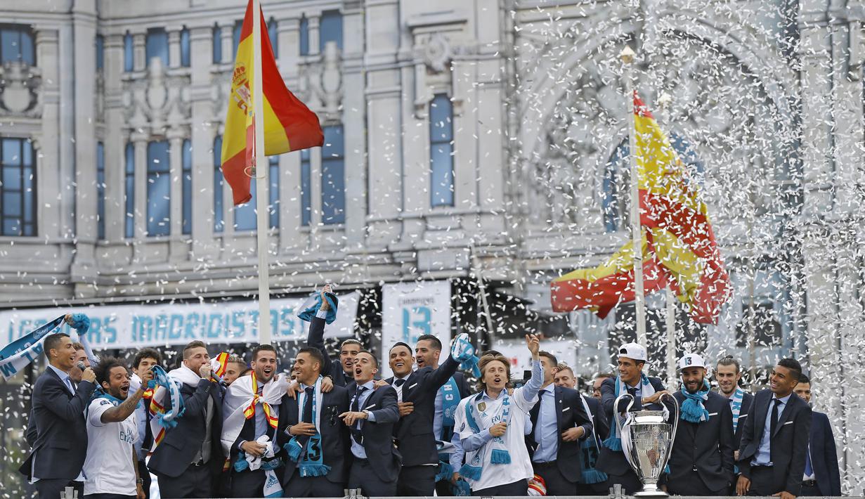 Para pemain Real Madrid merayakan kemenangan Liga Champions di Monumen Cibeles, Madrid, Minggu (27/5/2018). Real Madrid menggelar pawai kemenangan bersama fans usai menjuarai Liga Champions 2018. (AP/Francisco Seco)
