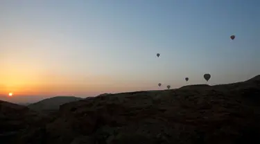 Sejumlah balon udara yang membawa wisatawan terbang saat matahari terbit di atas kota Luxor, Kairo, Mesir (13/12). Luxor adalah sebuah kota modern yang terletak di kedua tepi timur dan barat Sungai Nil di Mesir bagian utara. (Reuters/Amr Abdallah Dalsh)