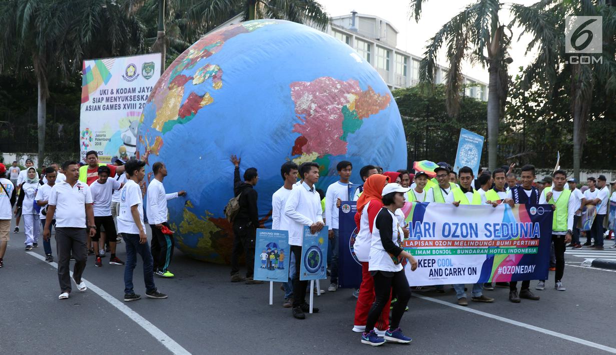 Replika bola dunia berukuran besar digelindingkan di sekitar kawasan Bundaran HI, Jakarta, Minggu (16/9). Acara ini bagian dari peringatan Hari Ozon Sedunia 2018 dengan tema Keep Cool and Carry on! The Montreal Protocol. (Liputan6.com/Helmi Fithriansyah)
