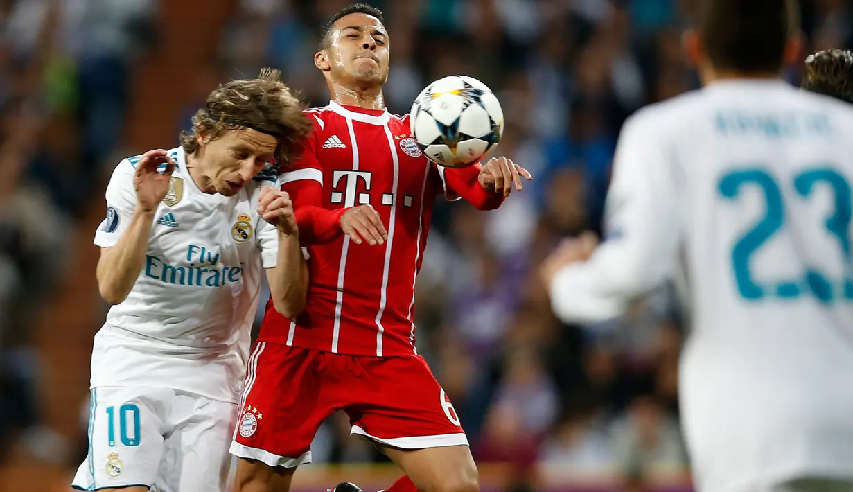 Pemain Bayern Munchen Thiago berebut bola dengan pemain Real Madrid Luka Modric saat pertandingan semifinal Liga Champions di stadion Santiago Bernabeu, Spanyol (1/5). Real Madrid menyingkirkan Bayern Muenchen dengan agregat 4-3. (AP/Francisco Seco)