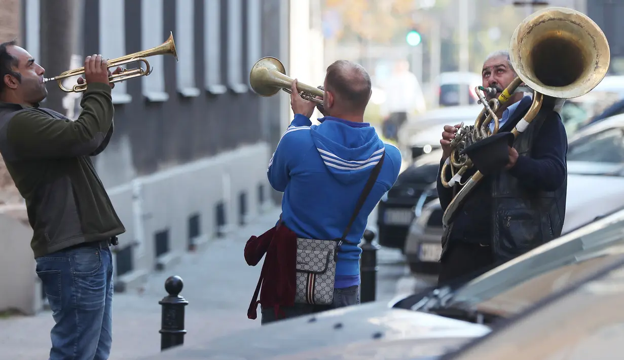 Orkes tiup musisi Rumania menghibur pejalan kaki untuk mendapat uang di Warsawa, Polandia pada 21 Oktober 2019. Orkes tiup yaitu sekelompok orang yang memperagakan musik dengan menggunakan instrumen musik tiup baik tiup logam maupun tiup kayu.  (AP Photo/Czarek Sokolowski)