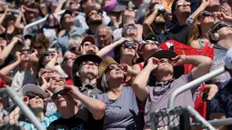 Orang-orang melihat gerhana di kampus Southern Illinois University pada tanggal 08 April 2024 di Carbondale, Illinois. (Scott Olson/Getty Images North America/Getty Images via AFP)