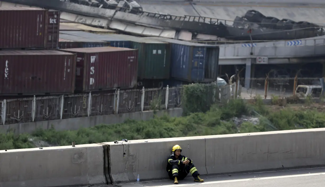 Petugas pemadam beristirahat di pinggir jalan dekat lokasi ledakan di pelabuhan Kota Tianjin, China, Kamis (13/8/2015). Ledakan yang diperkirakan berkekuatan setara 21 ton TNT ini menewaskan 17 orang dan ratusan lainya terluka. (REUTERS/Jason Lee)