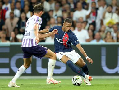 Bek Toulouse #02 Rasmus Nicolaisen berebut bola dengan penyerang Paris Saint-Germain (PSG) #07 Kylian Mbappe pada pekan ke-2  Ligue 1  2023/2024 di Stadion de Toulouse pada Minggu (20/8/2023) dinihari WIB. (Charly TRIBALLEAU / AFP)