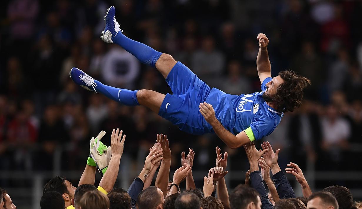 Mantan bintang timnas Italia, Andrea Pirlo diangkat oleh sejumlah pemain usai pertandingan perpisahan Andrea Pirlo di Stadion San Siro, Milan, Italia, (21/5). (AFP Photo / Marco Bertorello)