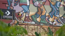 Seniman menyelesaikan pembuatan mural dalam acara Converse City Forest di Fatmawati, Jakarta, Sabtu (6/3/2021).  Mural digambar menggunakan cat khusus Grephenstone yang dapat menyerap polusi udara setara 177 pohon. (Liputan6.com/Faizal Fanani)