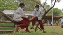 Dua murid SD bermain di atas pohon di sekolah alam Sukawangi, Kabuapaten Bekasi, Jawa Barat, Senin (30/11/2020). Kegiatan bermain di alam terbuka menjadi solusi bagi para murid untuk menghilangkan rasa jenuh usai belajar dimasa pandemi COVID-19. (Liputan6.com/Herman Zakharia)