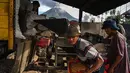 Para petani bekerja dengan latar belakang Gunung Sinabung yang menyemburkan abu dan asap tebal, sebagaimana terlihat dari Karo, Provinsi Sumatra Utara, Rabu, 2 September 2026. (AFP/ YT Haryono)