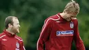 Wayne Rooney and Peter Crouch share a joke as they walk to the training ground for training at London Colney, North London, on October 7, 2008. AFP PHOTO/Glyn Kirk