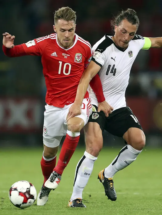 Pemain Wales, Aaron Ramsey (kiri) berebut bola dengan pemain Austria, Julian Baumgartlinger pada laga Group D kualifikasi Piala Dunia 2018 di Cardiff City Stadium, Cardiff, (2/8/2017). Wales menang 1-0. (David Davies/PA via AP)