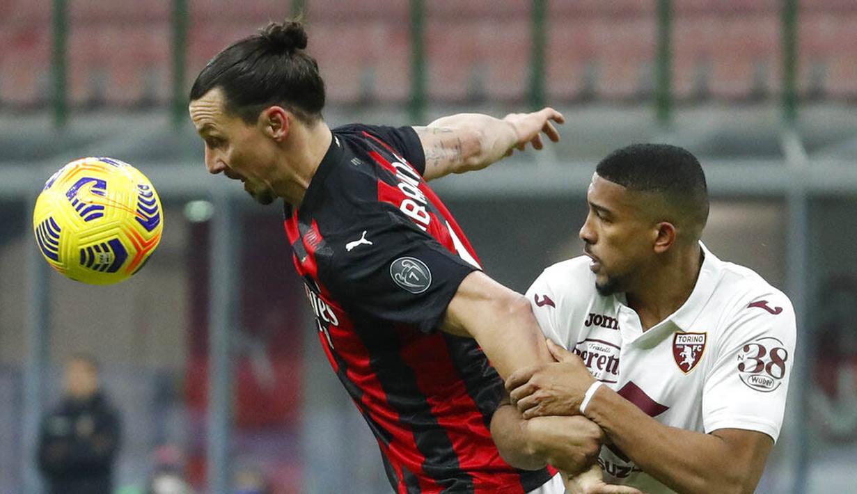 Striker AC Milan, Zlatan Ibrahimovic, berebut bola dengan pemain Torino, Gleison Bremer, pada laga Coppa Italia di Stadion San Siro, Selasa (12/1/2021). AC Milan menang adu penalti dengan skor 5-4. (AP/Antonio Calanni)