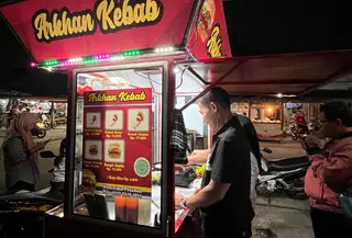 Samuri (58) sedang melayani pelanggan di tempat usahanya Arkhan Kebab