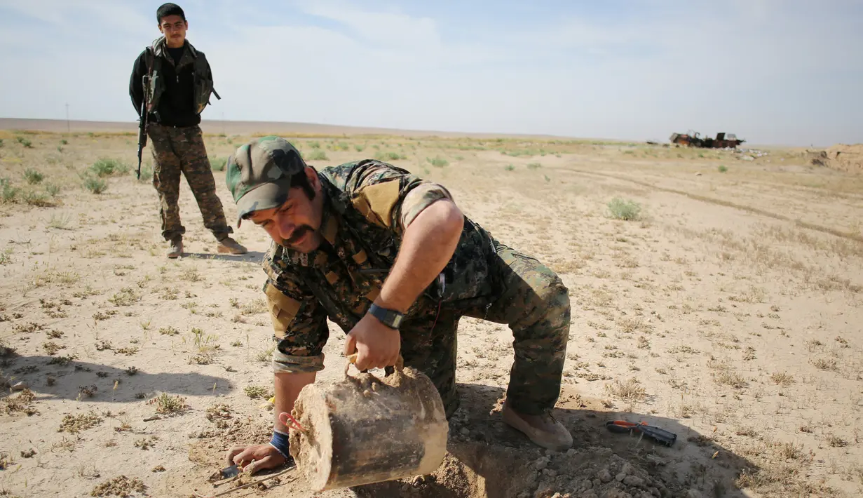 Anggota YBS yang berafiliasi dengan Partai Pekerja Kurdistan (PKK) menemukan ranjau  di sebuah jalur yang biasa dilintasi ISIS, Irak utara, 30 April 2016. Mereka juga berpatroli mencari ranjau darat yang dipasang ISIS sebelumnya. (REUTERS/Goran Tomasevic)