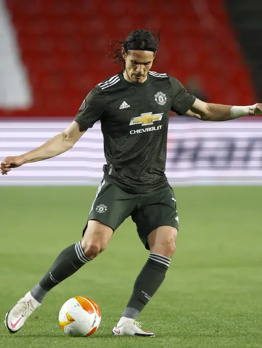 Penyerang Manchester United, Edison Cavani menendang bola saat bertanding melawan Granada pada pertandingan leg pertama perempat final Liga Europa di stadion Los Carmenes di Granada, Spanyol, Jumat (9/4/2021). MU menang atas Granada 2-0. (AP Photo/Fermin Rodriguez)