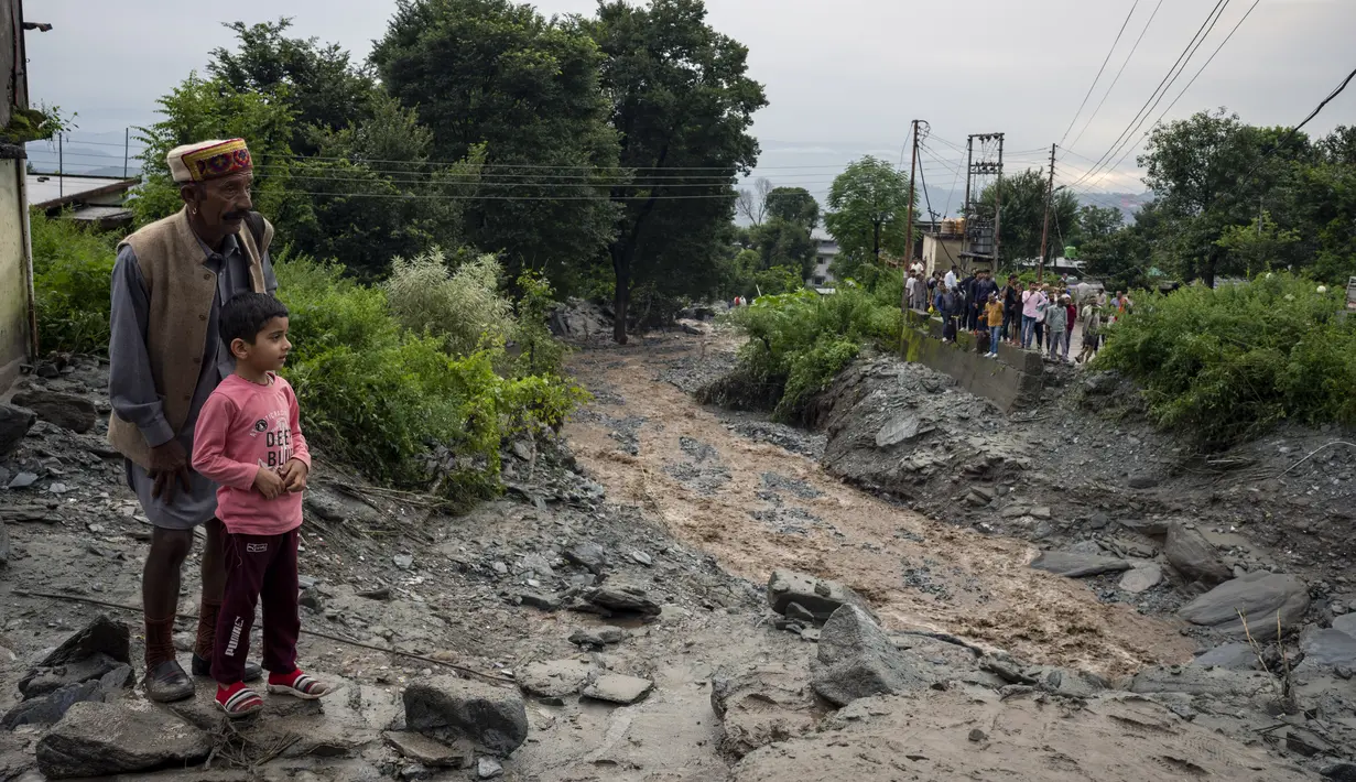 Orang-orang menyaksikan kerusakan yang disebabkan oleh tanah longsor setelah hujan deras di Khaniyara, dekat Dharmsala, India (2/9/2022). Tidak ada korban jiwa yang dilaporkan akibat musibah tersebut. (AP Photo/Ashwini Bhatia)