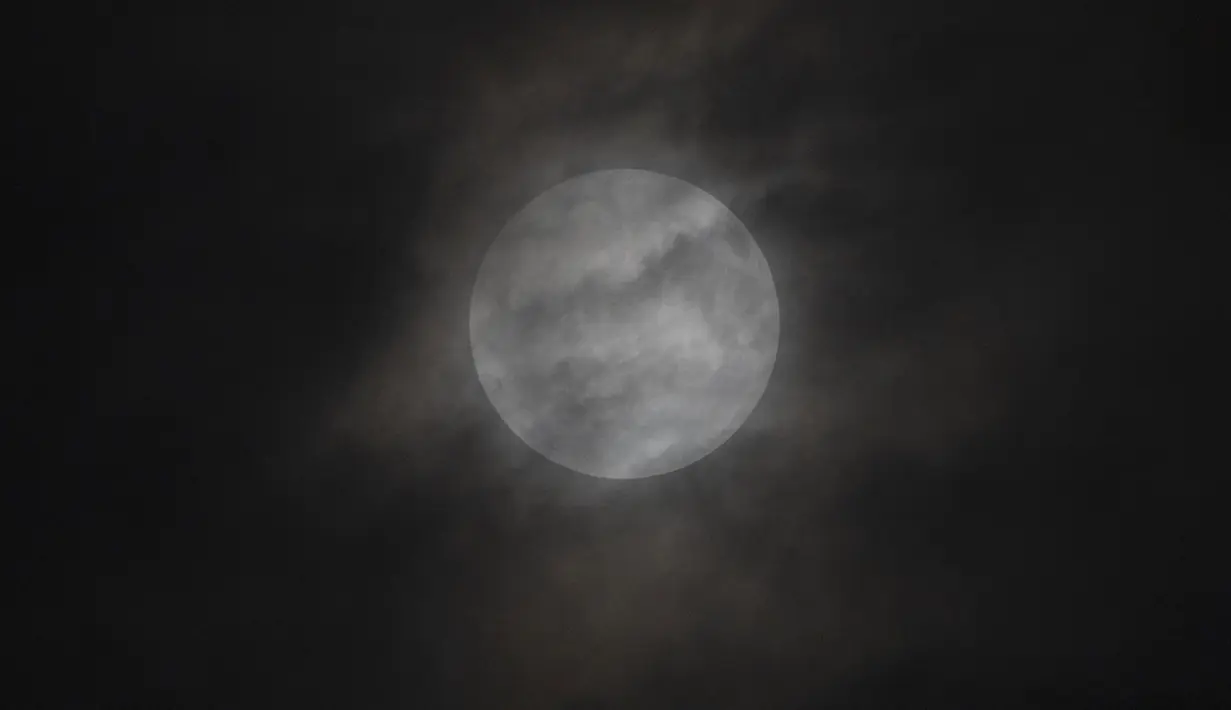 Gerhana bulan penumbra terlihat melalui awan di Beijing, China pada Sabtu dini hari (6/5/2023). Gerhana Bulan Penumbra malam nanti bisa dilihat dari belahan mana pun di seluruh dunia di mana Bulan berada di atas garis horison termasuk Antartika, Asia, Rusia, Oseania, dan Afrika Tengah hingga timur. (AP Photo/Ng Han Guan)