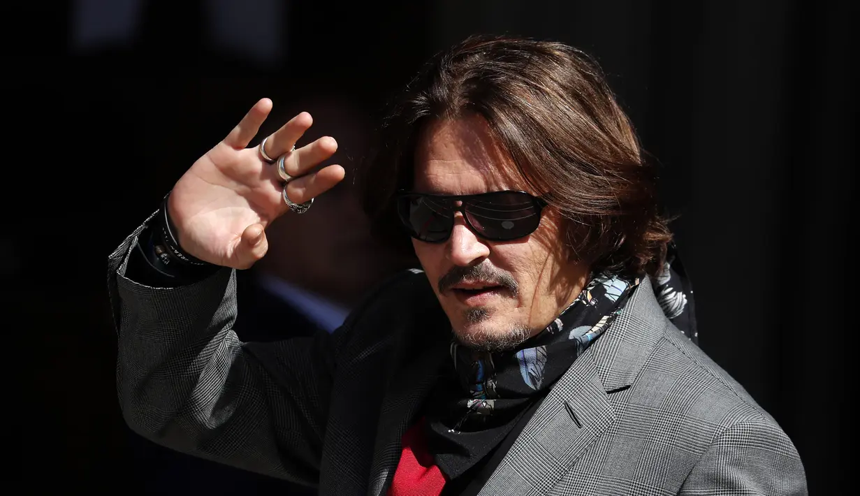 Aktor Johnny Depp memakai kacamata hitam dan syal saat menghadiri sidang pencemaran nama baik di Pengadilan Tinggi, London, Inggris, Selasa (21/7/2020). Johnny Depp menggugat tabloid The Sun atas artikel yang menyebut dirinya telah melakukan kekerasan terhadap sang istri. (AP Photo/Frank Augstein)
