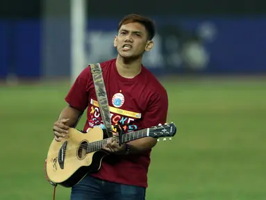 Salah satu suporter memainkan gitar akustik mengiringi nyanyian pendukung tim Macan Kemayoran usai menyaksikan laga Persija melawan Persipura di Stadion Patriot Candra Bhaga, Bekasi, Sabtu (8/7). (Liputan6.com/Helmi Fithriansyah)