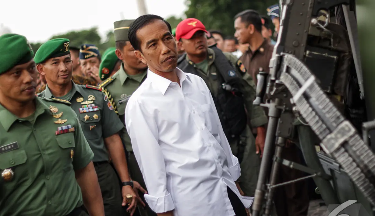 Presiden Jokowi memperhatikan sebuah senjata saat di Pameran  Alutsista TNI AD, Jakarta, Rabu (17/12/2014). (LIputan6.com/Faizal Fanani)