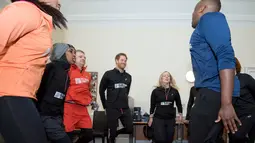 Pangeran Harry melakukan pemanasan bersama relawan dan para tunawisma sebelum berlari di Willesden Green, Inggris (26/1). Amal ini bekerja sama dengan beberapa warga dari asrama yang didirikan oleh badan amal Depaul. (Geoff Pugh, Foto Renang via AP)