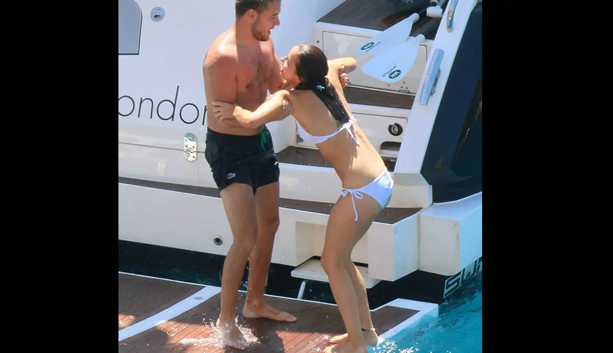 Anggota boyband One Direction itu mengenakan celana pendek, sedang sang kekasih mengenakan bikini berwarna putih. (Dailymail)