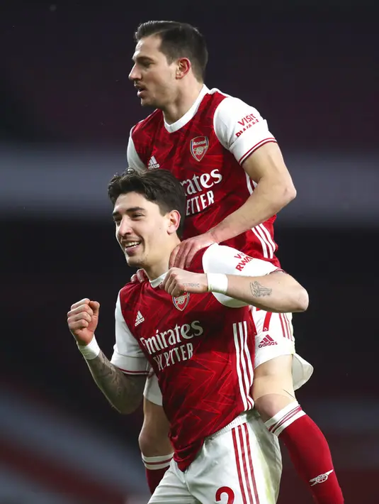 Pemain Arsenal Hector Bellerin merayakan dengan rekan setimnya Cedric Soares usai mencetak gol ke gawang Leeds United pada pertandingan Liga Inggris di Emirates Stadium, London, Inggris, Minggu (14/2/2021). Arsenal sikat Leeds United 4-2 dengan hattrick dari Aubameyang. (Catherine Ivill Pool via AP)