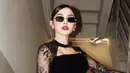 Melengkapi tampilannya dengan kacamata hitam serta aksesori anting-anting minimalis. [@mahaliniraharja]