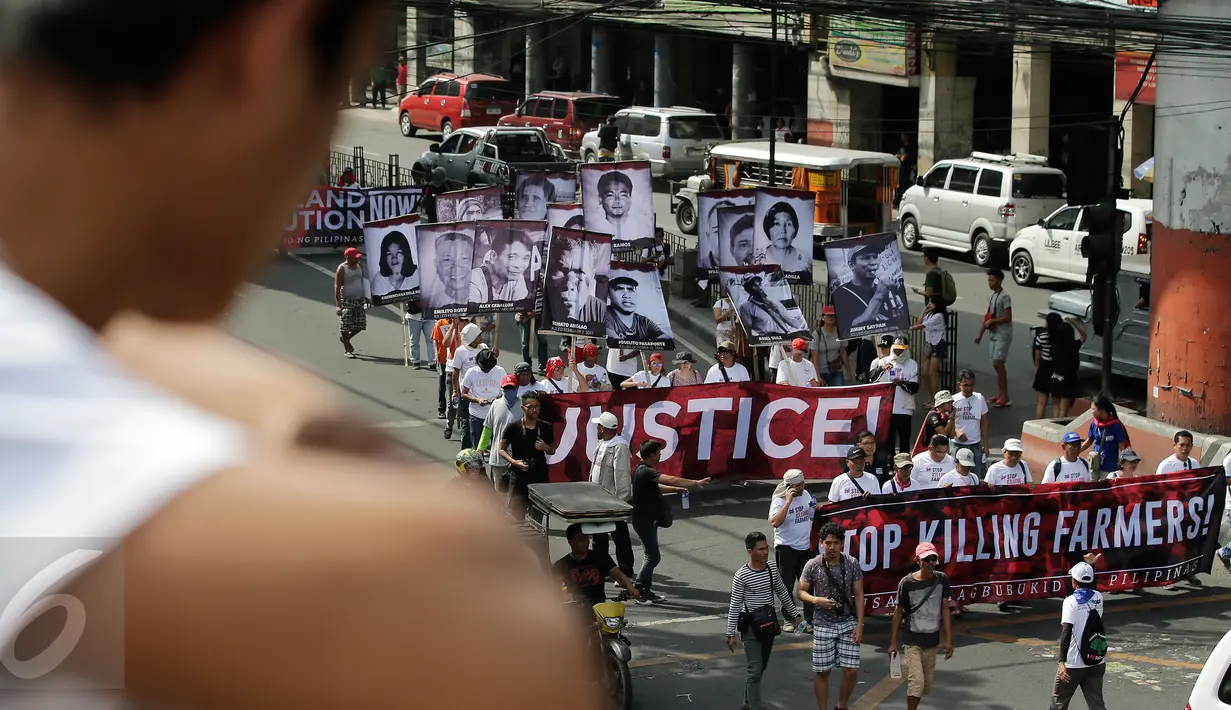 Demonstran menggelar aksi mengecam pembunuhan oleh Tentara Rakyat Baru, Manila, Filipina, Jumat (31/3). Mereka meminta Presiden Duterte untuk membicarakan perdamaian dengan pemberontak agar tidak membunuhi petani. (AP Photo / Aaron Favila)
