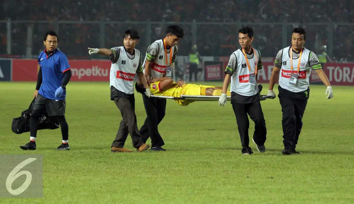 Pemain Sriwijaya FC, Wildansyah dievakuasi saat laga melawan Persija dilanjutan Torabika Soccer Championship presented by IM3 Ooredoo di Stadion GBK Jakarta, Jumat (24/6). Laga dihentikan, Sriwijaya FC unggul 1-0. (Liputan6.com/Helmi Fithriansyah)