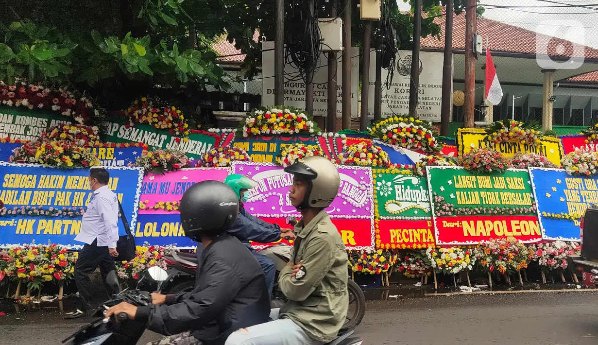 Pengguna jalan melintasi karangan bunga untuk terdakwa Hendra Kurniawan di depan Pengadilan Negeri Jakarta Selatan, Senin (27/2/2023). Mantan Karo Paminal Divpropam Polri Hendra Kurniawan akan menjalani sidang vonis dalam perkara kasus "Obstruction of Justice" atau perintangan penyidikan terkait penanganan pembunuhan berencana Nofriansyah Yosua Hutabarat alias Brigadir J. (Liputan6.com/Angga Yuniar)