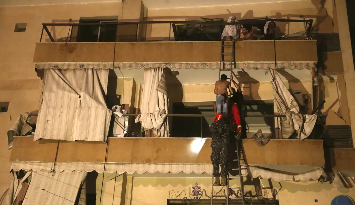 Orang-orang dievakuasi oleh Petugas Pemadam Kebakaran dari apartemen mereka setelah sebuah tangki bensin meledak di lingkungan Tarik al-Jadida, di Beirut, Lebanon (9/10/2020) waktu setempat.  (AP Photo/Bilal Hussein)