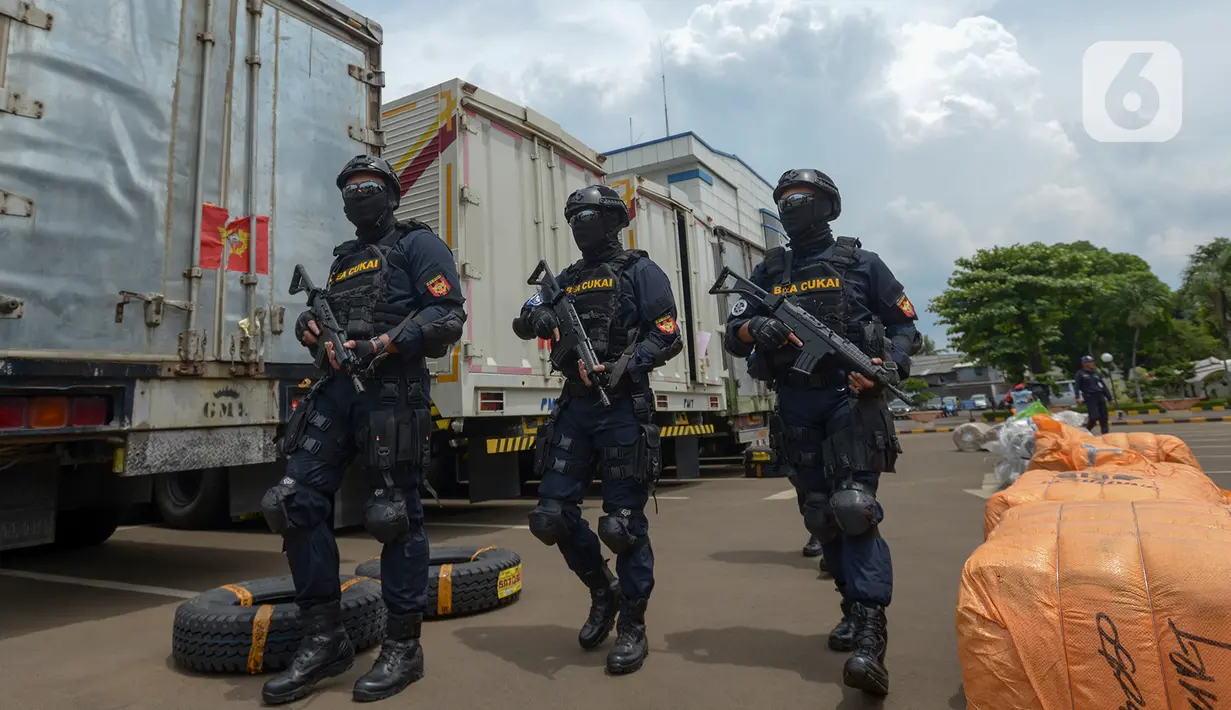 Sejumlah petugas Direktorat Jenderal Bea dan Cukai (DJBC) Kementerian Keuangan membawa senjata saat menunjukkan barang bukti pakaian bekas selundupan di Jakarta, Rabu (11/3/2020). Barang bukti pakaian bekas selundupan yang disita ditaksir mencapai Rp 2,6 miliar. (merdeka.com/Imam Buhori)