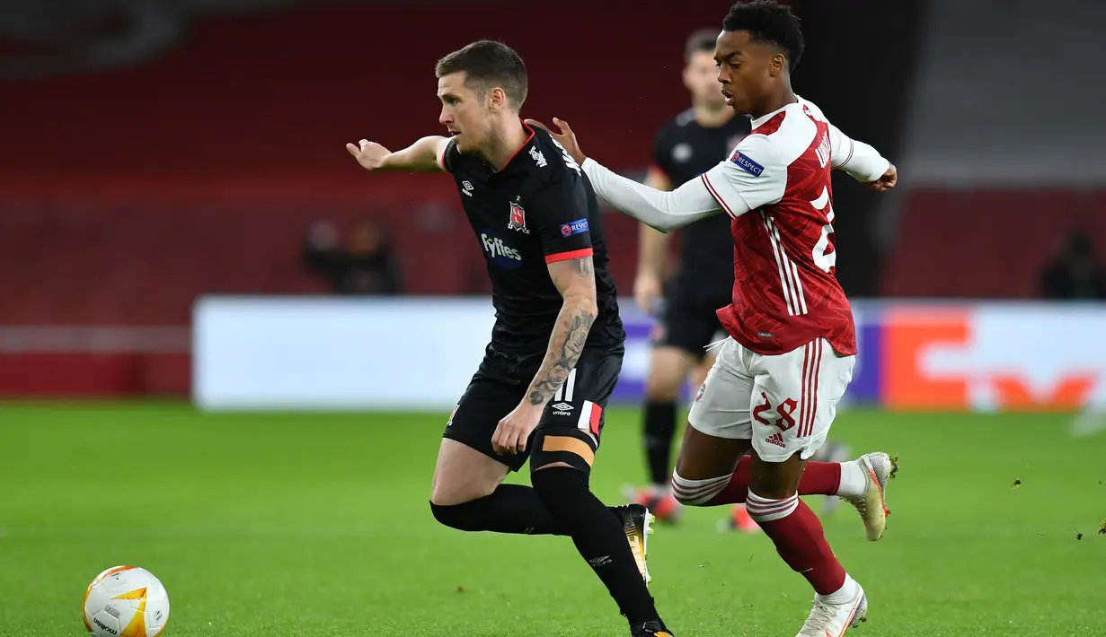 Gelandang Arsenal, Joe Willock, berebut bola dengan bek Dundalk, Daniel Cleary. pada laga lanjutan Liga Europa 2020/2021 di Emirates Stadium, Jumat (30/10/2020) dini hari WIB. Arsenal menang 3-0 atas Dundalk. (AFP/Glyn Kirk)