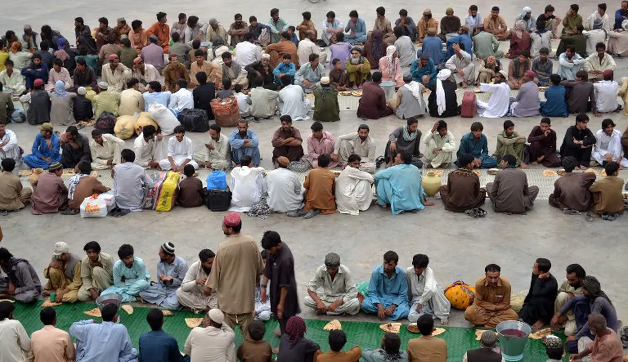 Mereka duduk berbaris dengan rapi dan saling berhadapan. Panjang barisan bisa mencapai 10 meter. Ratusan orang selalu berkumpul hampir setiap hari selama Ramadan, Quetta, Pakistan, Rabu (2/7/2014) (AFP PHOTO/BANARAS KHAN)