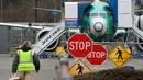 Pekerja Boeing berjalan ke arah  jet 737 Max di Renton, Washington, Senin (16/12/2019). Boeing Co mengumumkan akan menghentikan untuk sementara waktu produksi pesawat jenis 737 MAX – yang sudah dilarang terbang – pada Januari 2020 mendatang. (AP/Elaine Thompson)