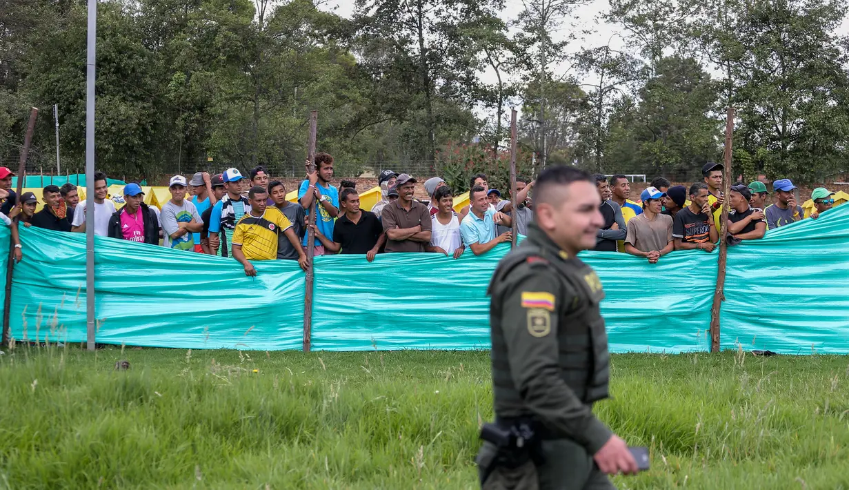 Para migran Venezuela menyaksikan sepak bola di kamp di Bogota, Kolombia (21/11). Pejabat kota menyelenggarakan turnamen sepak bola bagi migran yang tinggal di kamp yang dibangun badan kesejahteraan sosial kota tersebut. (AP Photo/Ivan Valencia)