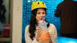 Aurelie terlihat lucu mengenakan helm karakter berbentuk kepala dino. Aktris yang pernah menjadi lawan main Ardhito Pramono ini tersenyum gemas sambil meminum air di tengah proses syuting. (Instagram/@aurelie)