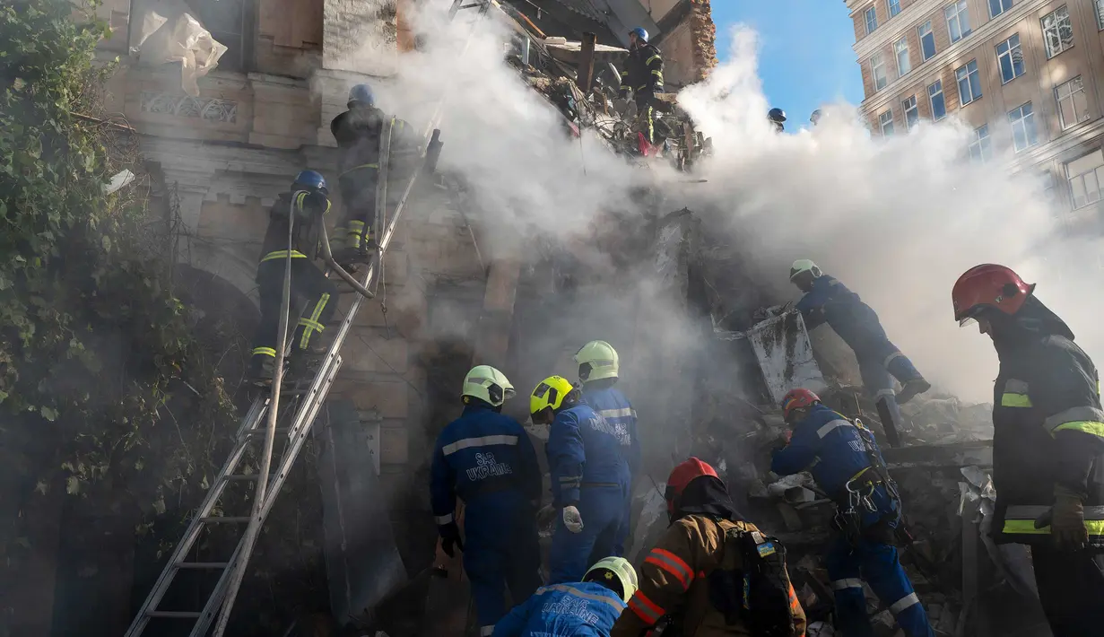 Petugas pemadam kebakaran bekerja setelah sebuah pesawat tak berawak menghantam gedung-gedung di Kyiv, Ukraina, Senin (17/10/2022).   Pesawat tak berawak menghantam sejumlah gedung ibu kota Ukraina pada Senin pagi ledakan tesebut menggema di seluruh Kyiv dan menimbulkan kepanikan sehingga orang-orang berlarian ke lokasi yang aman.  (AP Photo/Roman Hrytsyna)