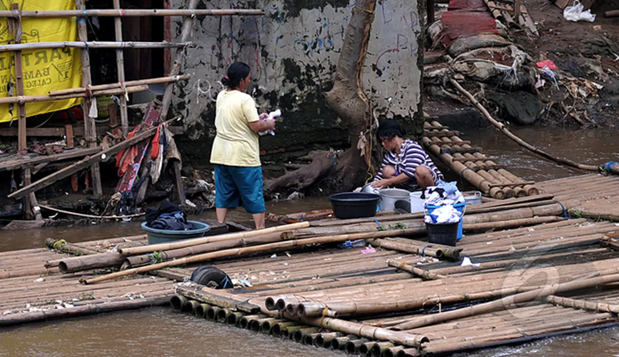 Masih banyak warga bantaran kali Ciliwung Jakarta yang memanfaatkan air kali untuk kehidupan sehari - hari. Tampak beberapa warga memanfaatkan air kali Ciliwung sebagai tempat Mandi Cuci Kakus (MCK), Jakarta, Jumat (20/2/2015). (Liputan6.com/JohanTallo)