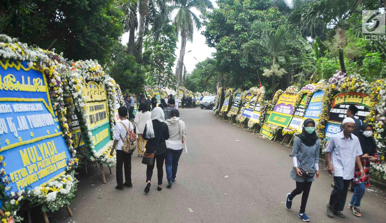 Warga berjalan di sekitar tempat persemayaman Ani Yudhoyono di Puri Cikeas, Bogor, Jawa Barat, Minggu (2/6/2019). Ani Yudhoyono akan dimakamkan di TMP Kalibata pada pukul 15.00 WIB.(Liputan6.com/Immanuel Antonius)