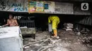 Petugas Sudin Bina Marga Provinsi DKI Jakarta merapikan kolong jembatan usai dihuni pemulung di Kelurahan Pegangsaan, Kecamatan Menteng, Kamis (7/1/2021). Penataan kolong jembatan bertujuan agar tempat itu tidak dijadikan tempat tinggal bagi tunawisma atau pemulung. (Liputan6.com/Faizal  Fanani)