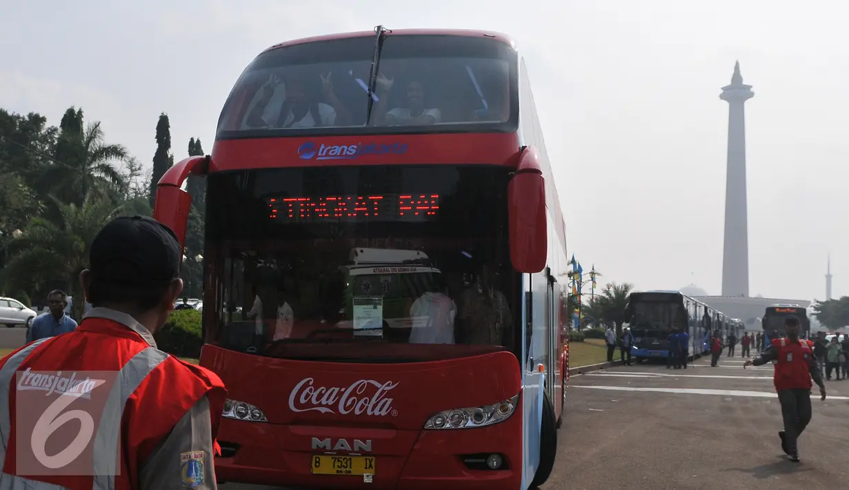 Petugas Transjakarta saat mengatur bus tingkat, Jakarta, Senin  (22/6/2015). Bus tingkat bermerek MAN buatan Jerman ini merupakan program Transjakarta untuk menambah layanan angkutan gratis bagi masyarakat Jakarta. (Liputan6.com/Herman Zakharia)