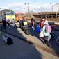 Orang-orang membawa barang-barang mereka saat berjalan untuk mengejar kereta api ke Budapest di stasiun di Zahony, Hungaria, 8 Maret 2022. PBB mengatakan, serangan gencar Rusia telah memaksa lebih dari 2 juta orang meninggalkan Ukraina. (AP Photo/Darko Vojinovic)