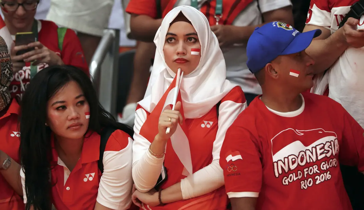 Suporter Indonesia tengah serius saat mendukung Tontowi Ahmad dan Liliyana Natsir meraih medali emas ada cabang bulutangkis pada Olimpiade Rio 2016 di Stadion Riocentro, Rio de Janeiro, (17/8/2016). (REUTERS/Mike Blake )
