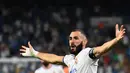 Pemain Real Madrid Karim Benzema melakukan selebrasi usai mencetak gol ke gawang Celta Vigo pada pertandingan Liga Spanyol di Stadion Santiago Bernabeu, Madrid, Spanyol, 12 September 2021. Karim Benzema mencetak hattrick saat Real Madrid mengalahkan Celta Vigo 5-2. (GABRIEL BOUYS/AFP)